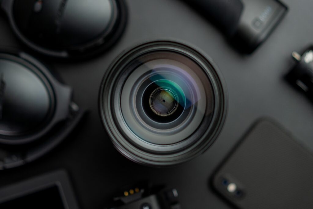 high angle shot of lens, headphones, gimbal, and phone